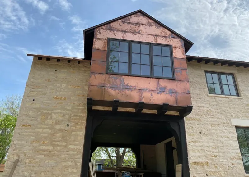 Copper metal panel facade on a stone building for Skylight Installation in Pepperell